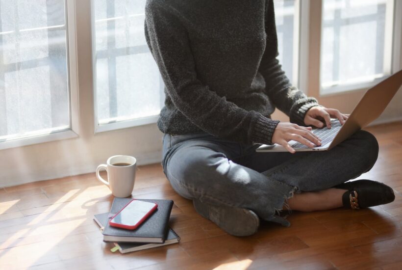 woman in gray sweat shirt sitting beside window